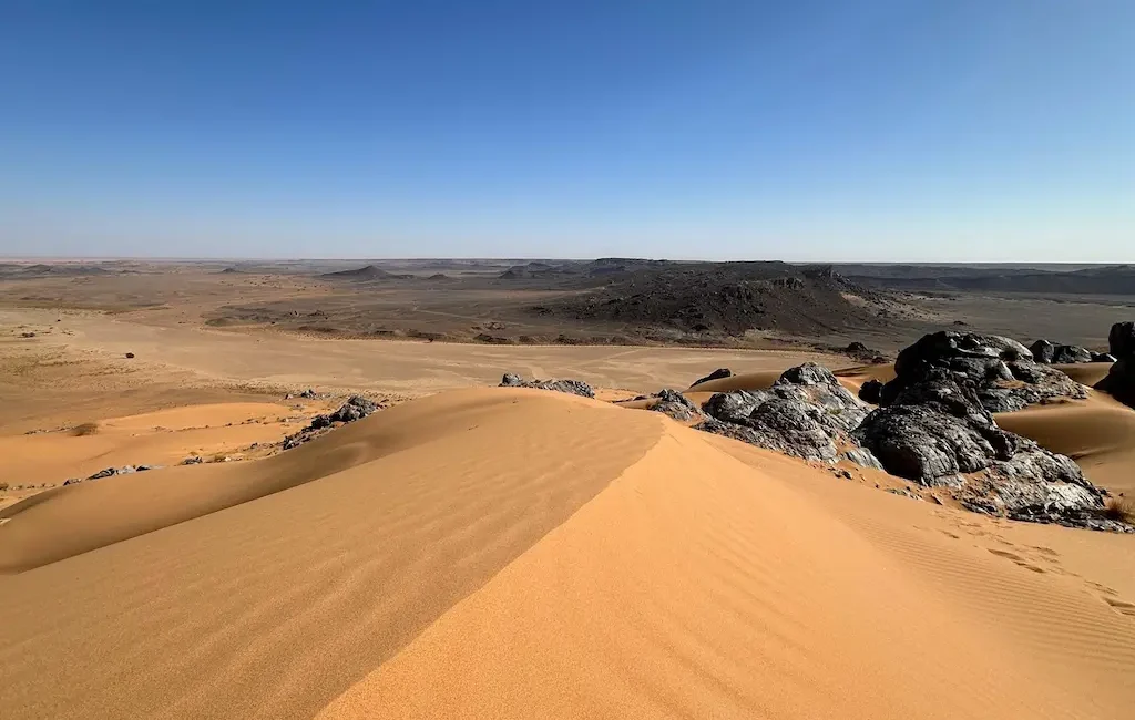 Paisaje Desierto Marruecos Paisaje panorámico de las dunas de Erg Chebbi con formaciones rocosas al fondo